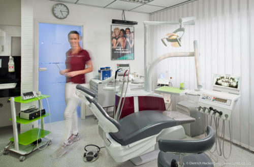 Mit einer Helferin Bewegungsunschärfe wirkt das Bild lebendig, aber die Ausstatung des Raumes bleibt im Focus. Behandlungszimmer Zahnarztpraxis. Foto Dietrich Hackenberg