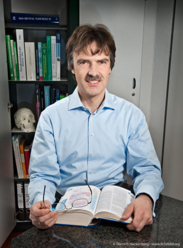 Im Büro "zivil" und mit Büchern. Das Motiv zeigt den Zahnarzt als Wissenschaftler. Foto Dietrich Hackenberg